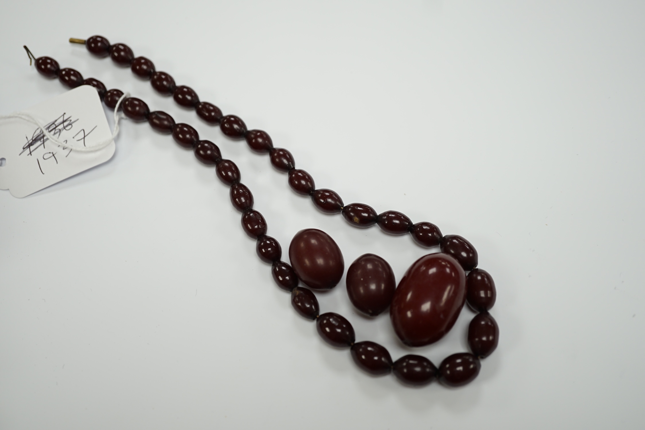 A single strand graduated simulated cherry amber bead necklace(a.f.), gross weight 50 grams.